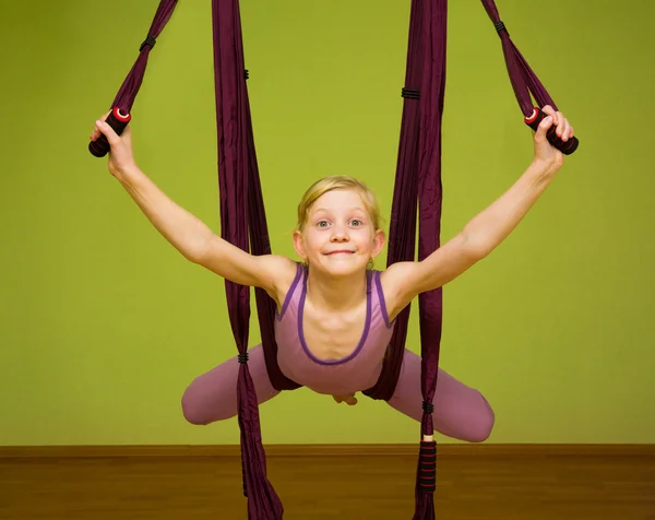 Little girl making aerial yoga exercises, indoor