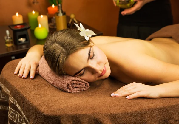 Woman in spa salon with orchid flower in her hair