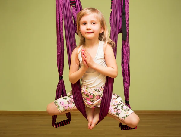 Little girl making aerial yoga exercises, indoor