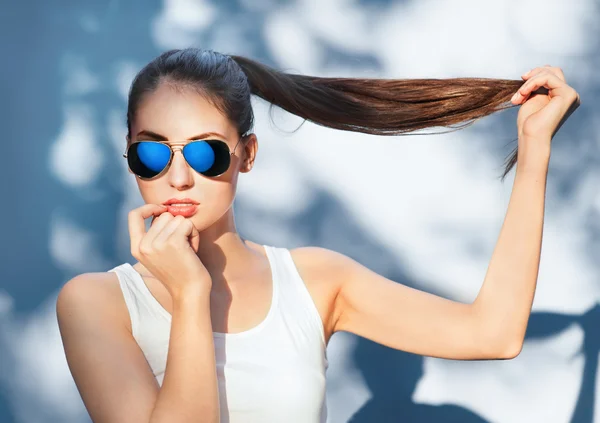 Attractive girl in mirrored blue sunglasses