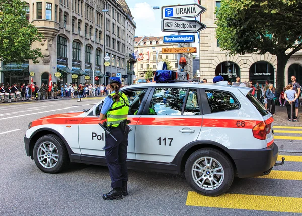 Policewoman watching the Swiss National Day parade in Zurich