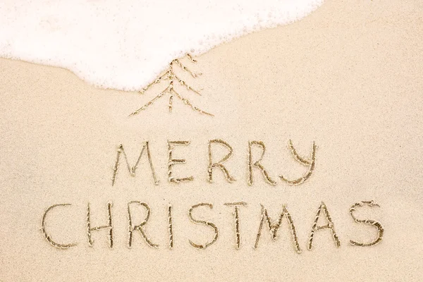 Merry Christmas written on wet sand