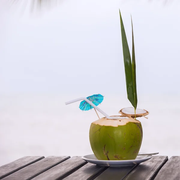Coconut water drink served in coconut with drinking straw on the