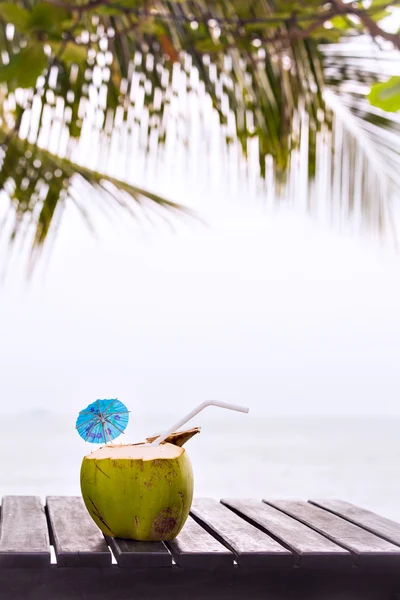 Coconut water drink served in coconut with drinking straw on the