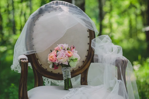 Wedding bouquet with roses and other flowers on armchair