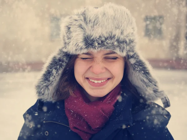 Cute funny girl in a fur cap laughing