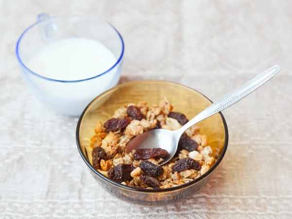 Muesli with dried fruit in a bowl and glass of milk, with select