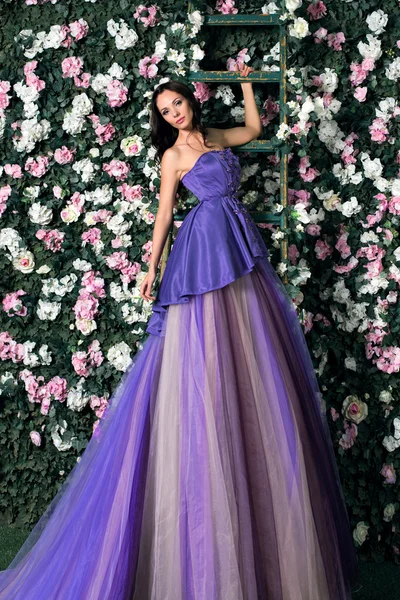 Woman in long purple dress in garden