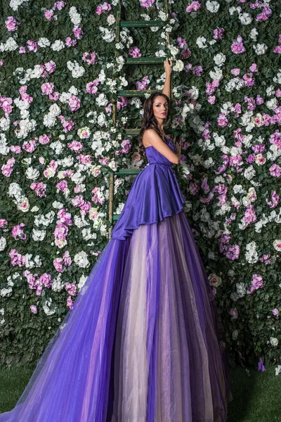 Woman in long purple dress in garden