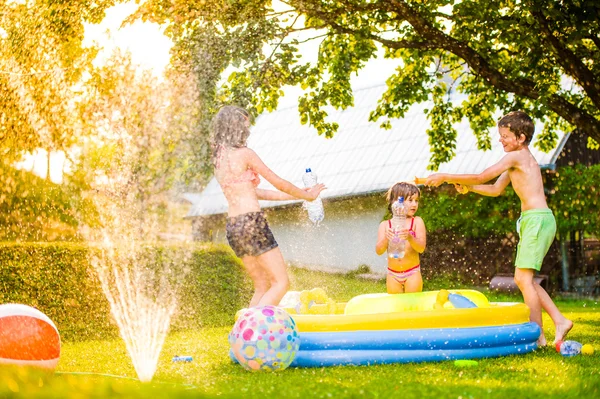 Boy splashing girls with water gun