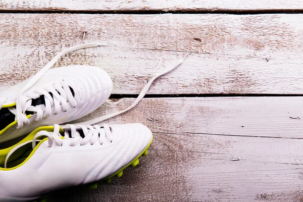 Soccer cleats against wooden background. Studio shot. Copy space.