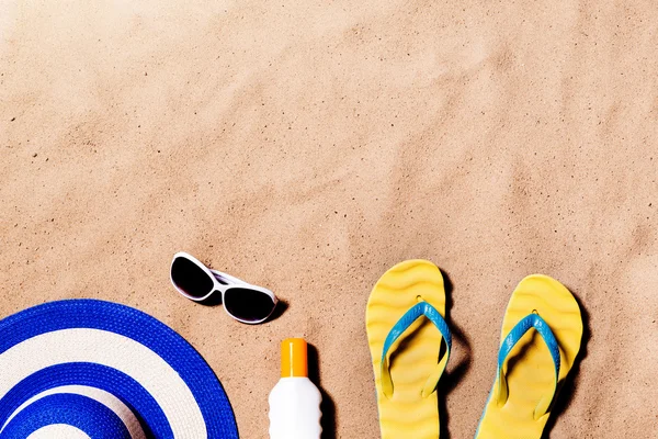 Pair of flip flop sandals, sunglasses, hat and sunscreen.