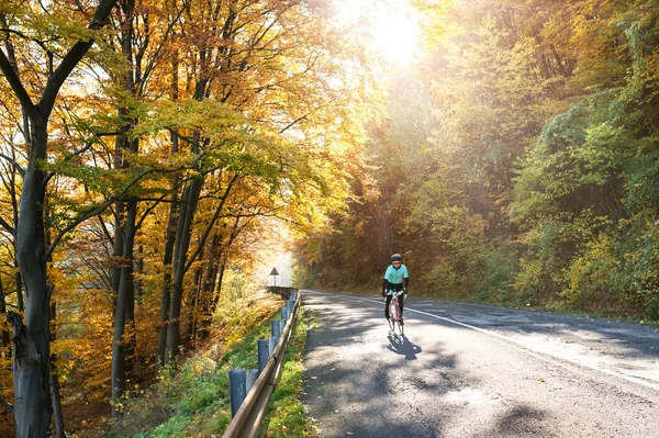 Sportsman riding bicycle in autumn