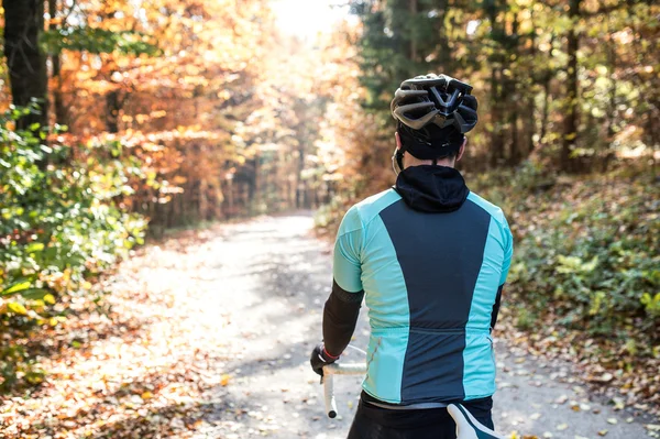 Sportsman riding bicycle in autumn