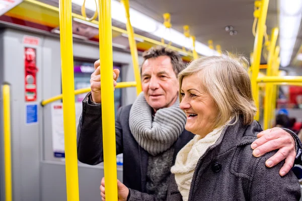 Senior couple standing in a crowded subway train