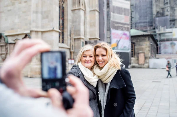 Women posing for pictures in centre of the city. Winter