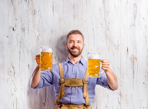 Man in bavarian clothes holding beer mugs