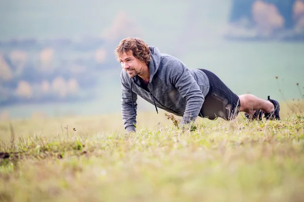 Young runner man doing push ups