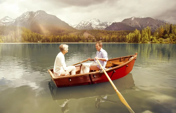 Senior couple paddling on boat