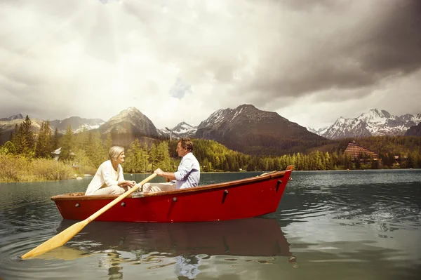 Senior couple paddling on boat