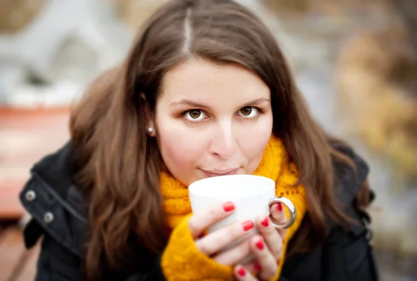 Woman holding a cup with hot drink