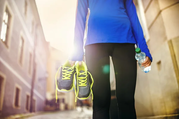 Female runner with shoes and bottle