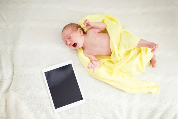 Newborn baby girl with digital tablet