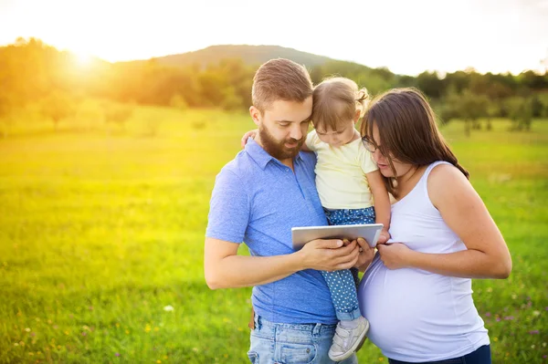 Mother, father and daughter with digital tablet