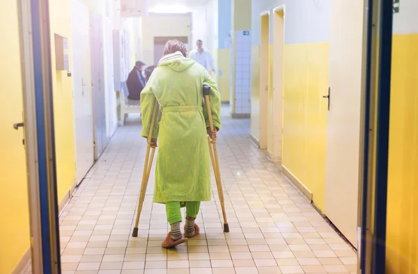 Senior woman walking with crutches