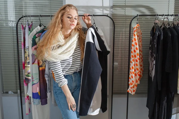 Girl chooses clothes in a boutique.