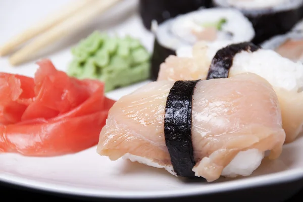 Salmon sushi with pickled ginger and mustard.