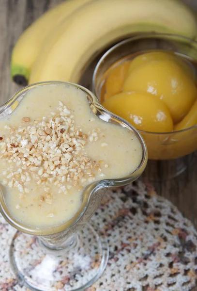 Smoothie of banana and canned peaches with nuts.