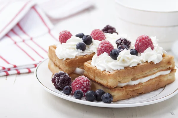 Soft waffles with protein cream, berry jam, whipped cream and b