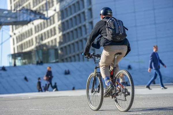 A worker cycling in large metropolital area
