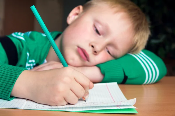 Tired boy doing difficult homework