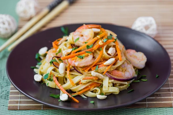 Asian noodles with shrimp, vegetables, carrots, peanuts, onions,
