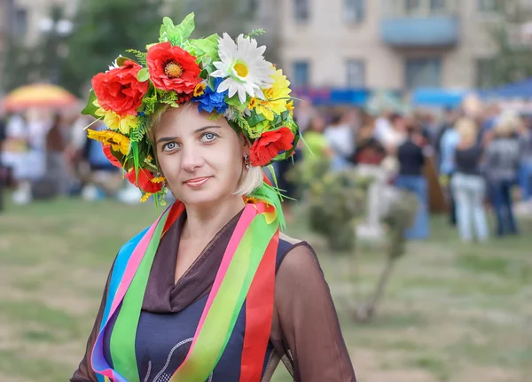 Fashionable national dress style. Pretty woman, Ukrainian, with a wreath of flowers and ribbons