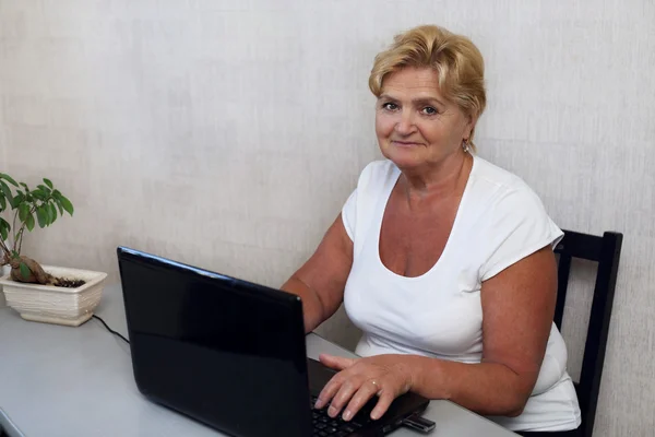 Elderly woman behind the laptop