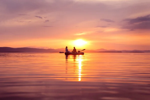 Man and woman in a boat at sunset