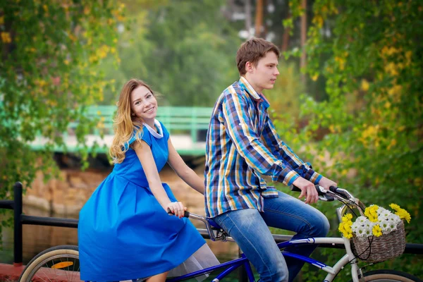 Happy young couple riding on a tandem bike