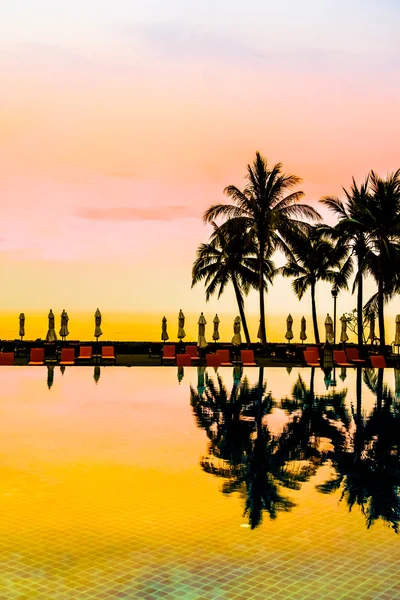 Silhouettes of palm trees on swimming pool