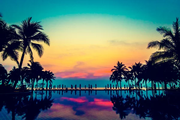 Silhouettes of palm trees on swimming pool
