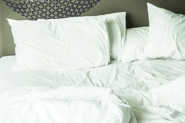 Rumpled bed with white messy pillow