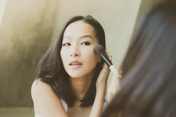 Woman with make up brush in hand