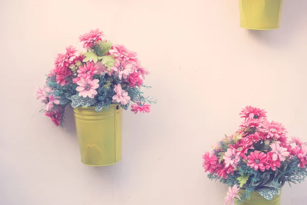 Vases with flowers on wall