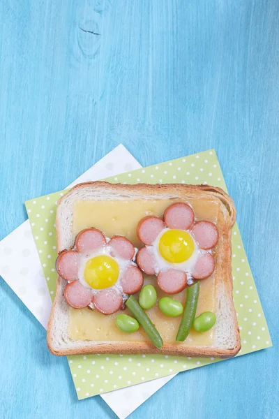 Funny toast with cheese, sausages, quail eggs and edamame