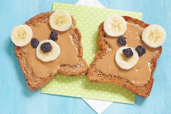 Funny bear face sandwich with peanut butter, banana and raisins