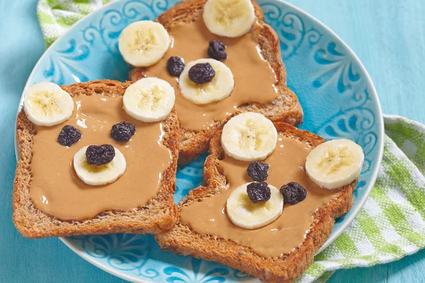 Funny bear face sandwich with peanut butter, banana and raisins