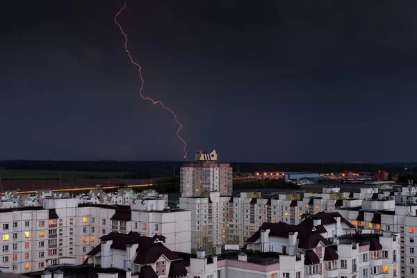 Lightning in the night sky over the city houses