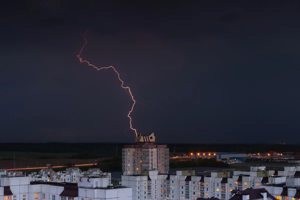 Lightning in the night sky over the city houses